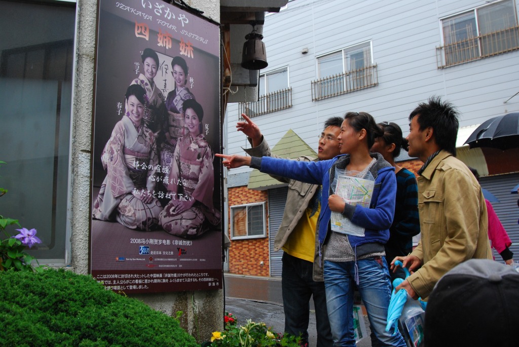 映画に登場する四姉妹のポスターを見る中国人客